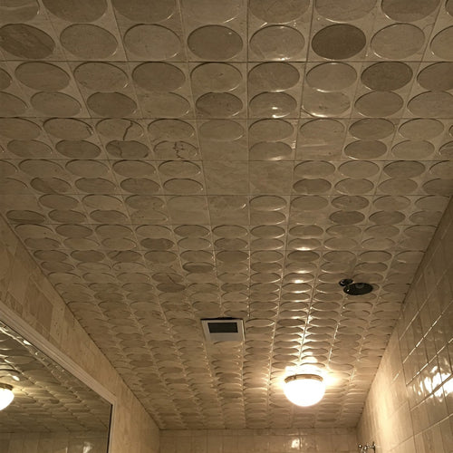 A bathroom ceiling covered with patterned porcelain tile spheres, creating a luxurious and unique look.