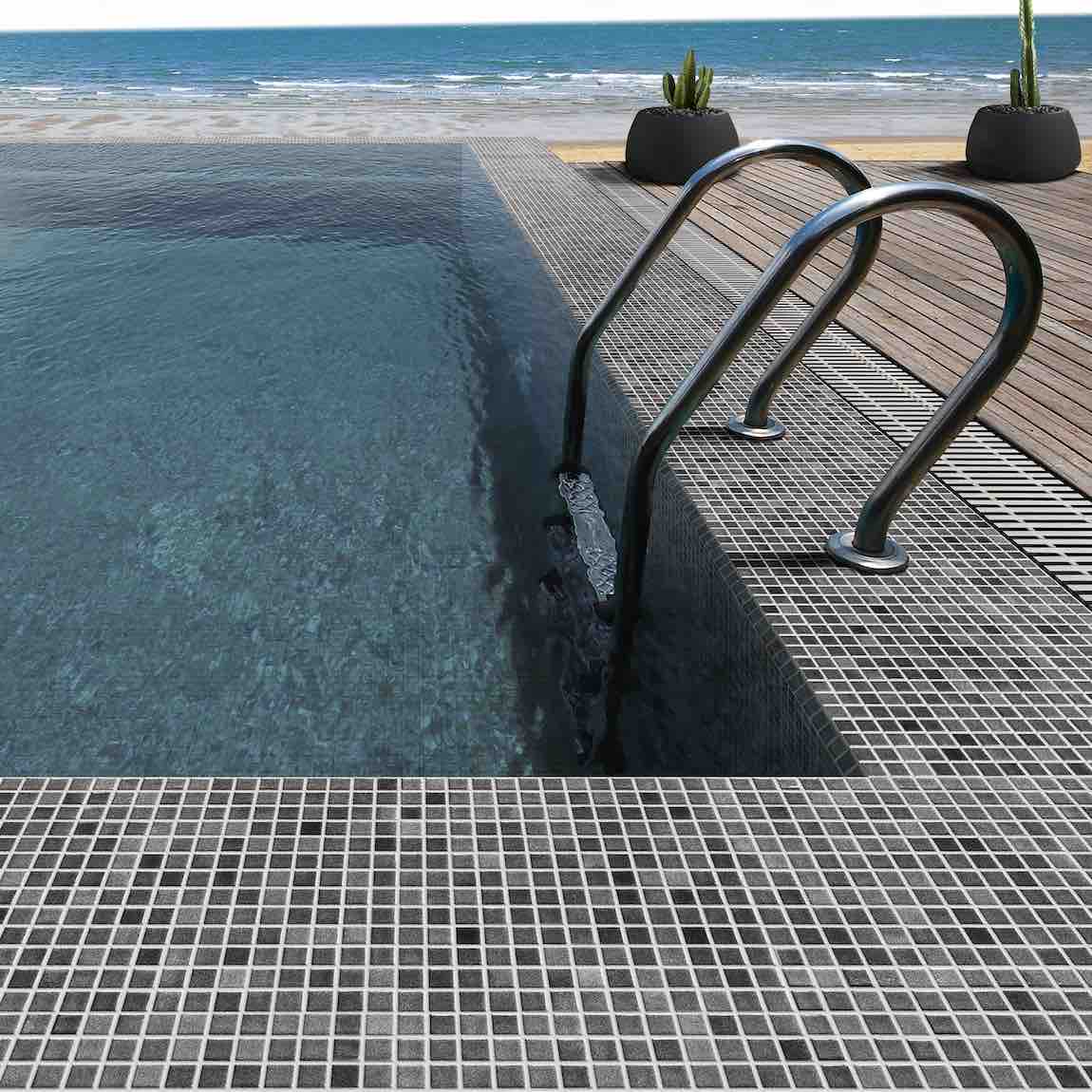 Recycled Glass Tile Fog Black 1x1 featured on a infinity swimming pool beach front