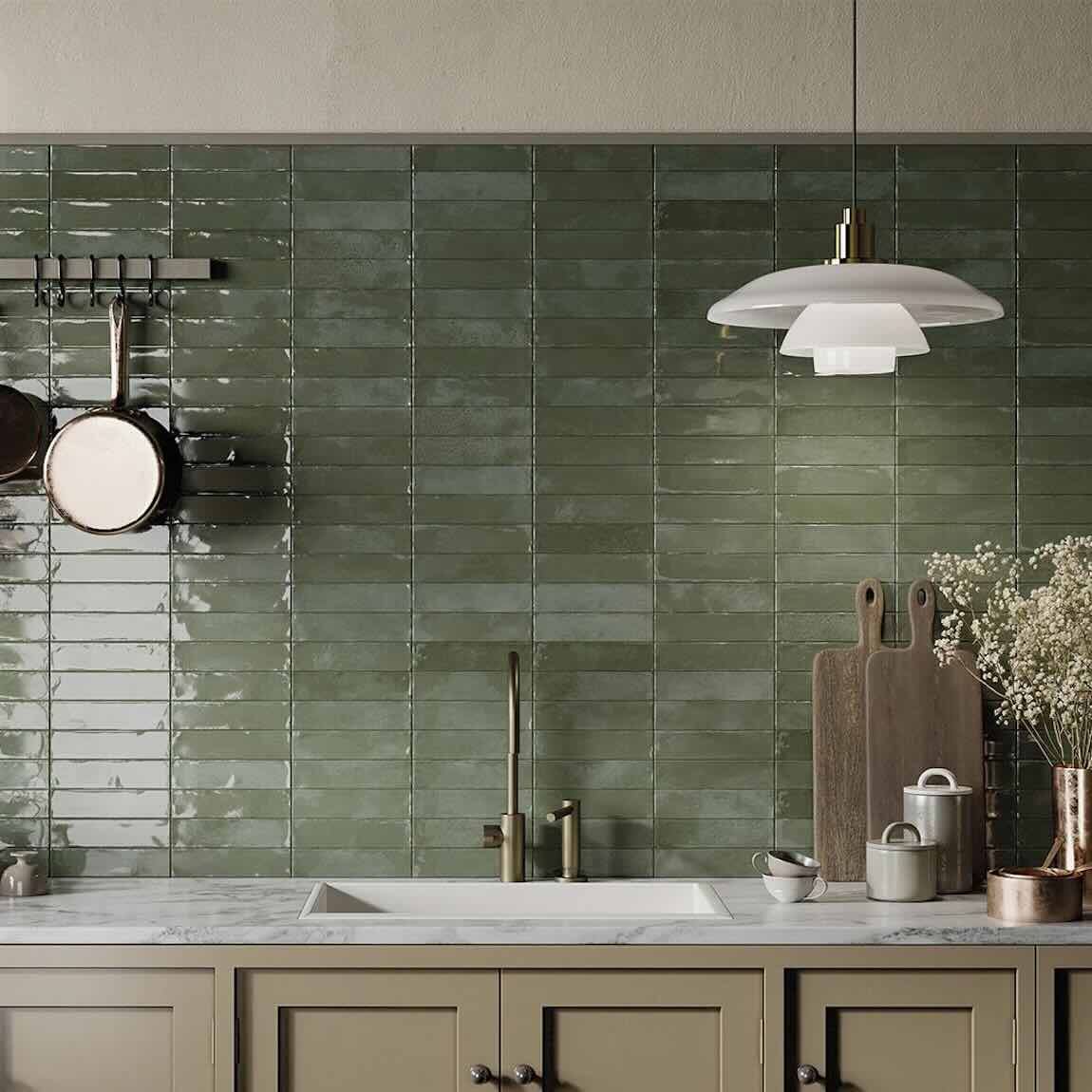 Charleston Green 2''x8'' Glossy Porcelain Zellige Tile featured on a kitchen backsplash with beige cabinets and white marble countertop