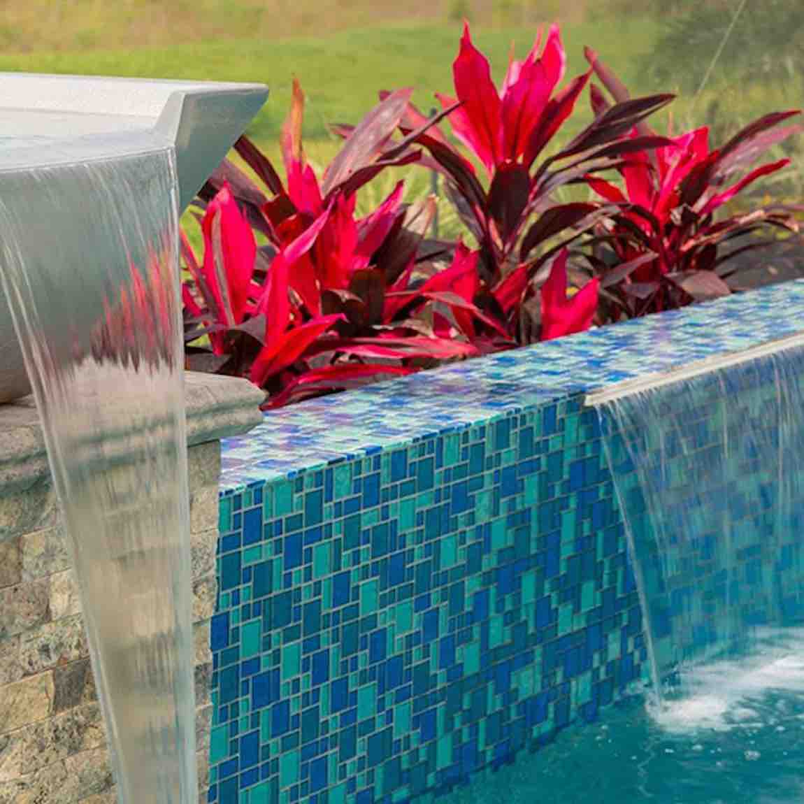 Iridescent Clear Glass Pool Tile Aqua Blend featured on a swimming pool waterfall