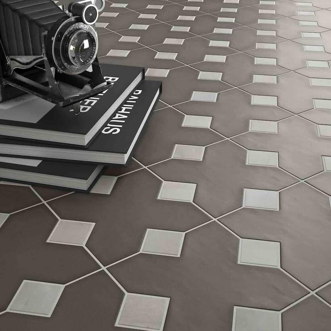 Hexagonal tiles with a geometric pattern on a floor, featuring a vintage camera and books.