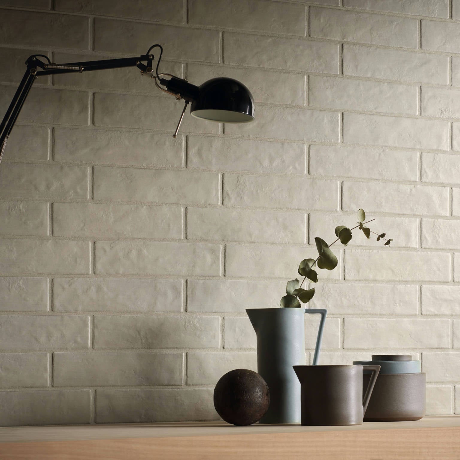 Brick-style porcelain tile in Perla color (3x11 inches) installed on a wall, creating a soft and elegant neutral-toned surface