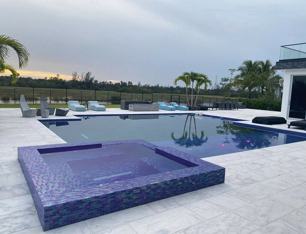 Iridescent glass tile in SoCal Cobalt Blue, sized 1x3, installed in a pool to reflect light with a dazzling, ocean-inspired shimmer that enhances the water’s richness and depth.