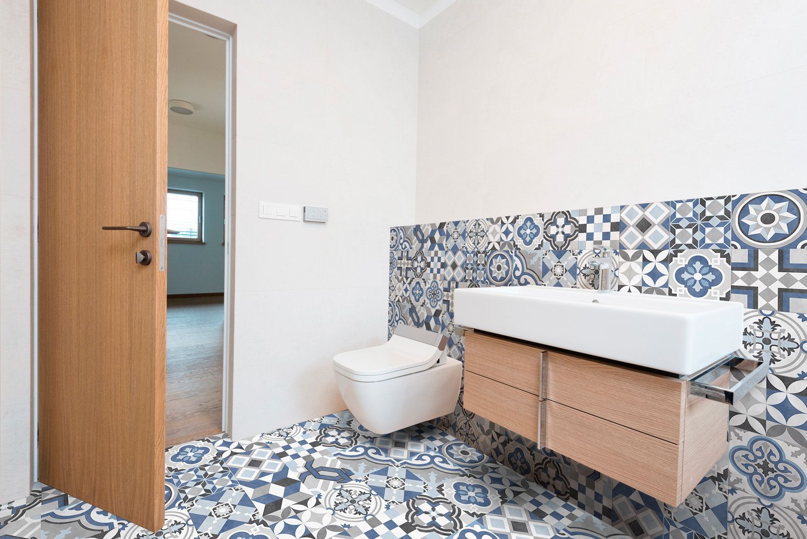 Blue geometric patterned porcelain tile installed on both the bathroom floor and wall, creating a cohesive, modern, and visually bold interior