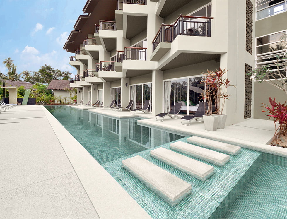 Light turquoise iridescent recycled glass tile installed in a swimming pool, offering a shimmering, eco-friendly surface that enhances the water's glow with a fresh, aquatic feel