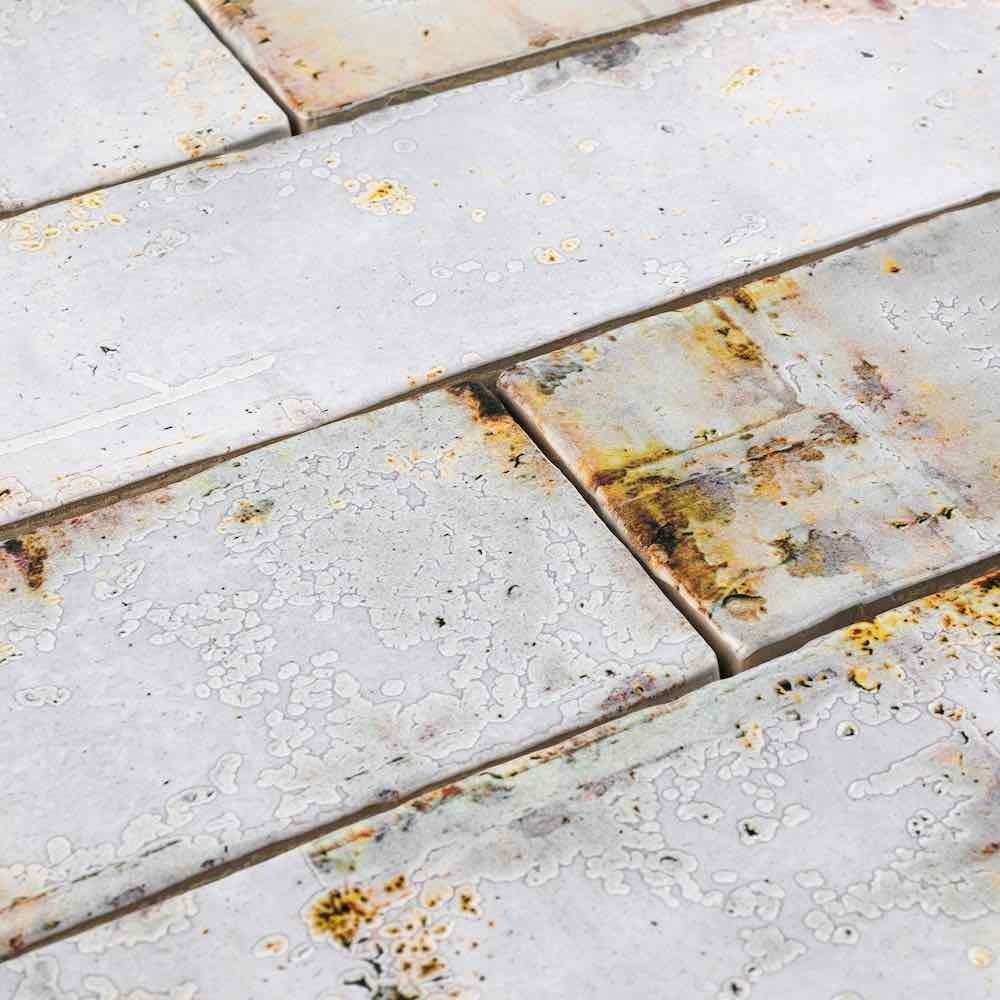 Close-up of rustic 3x12 Vintage Subway Tile in Rust with textured surface.