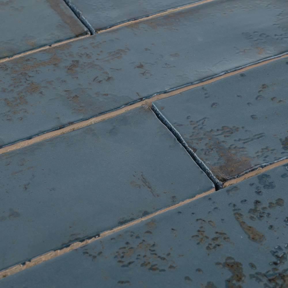 Close-up, angled view of textured 3x12 Vintage Subway Tile in blue with subtle variations in color.
