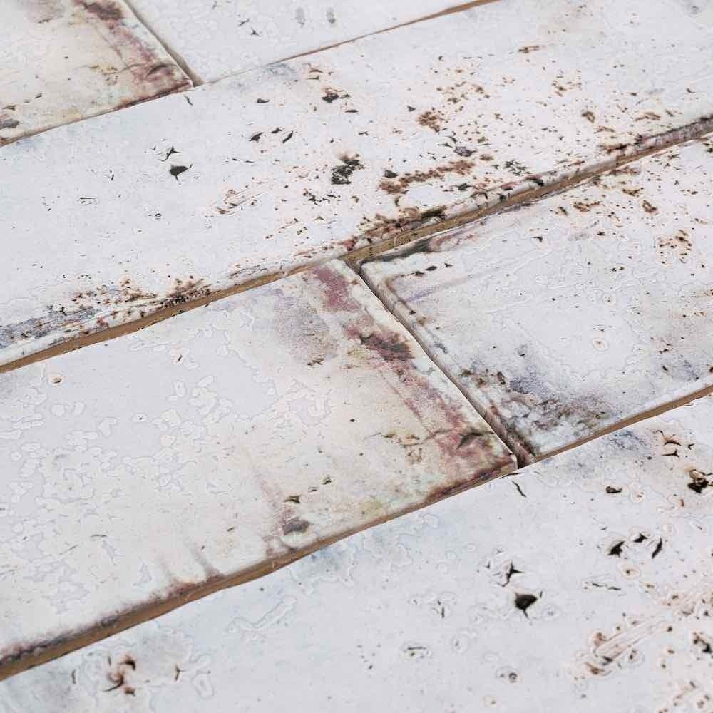 Detailed view of a textured 3x12 Vintage Subway Tile in Iron with varied white and darker markings
