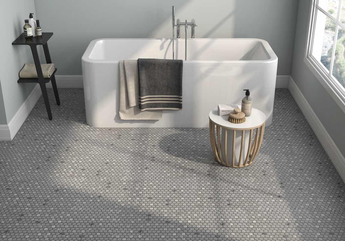 Stone gray penny round mosaic tile installed on a bathroom floor, providing a textured, slip-resistant surface with a stylish and timeless look