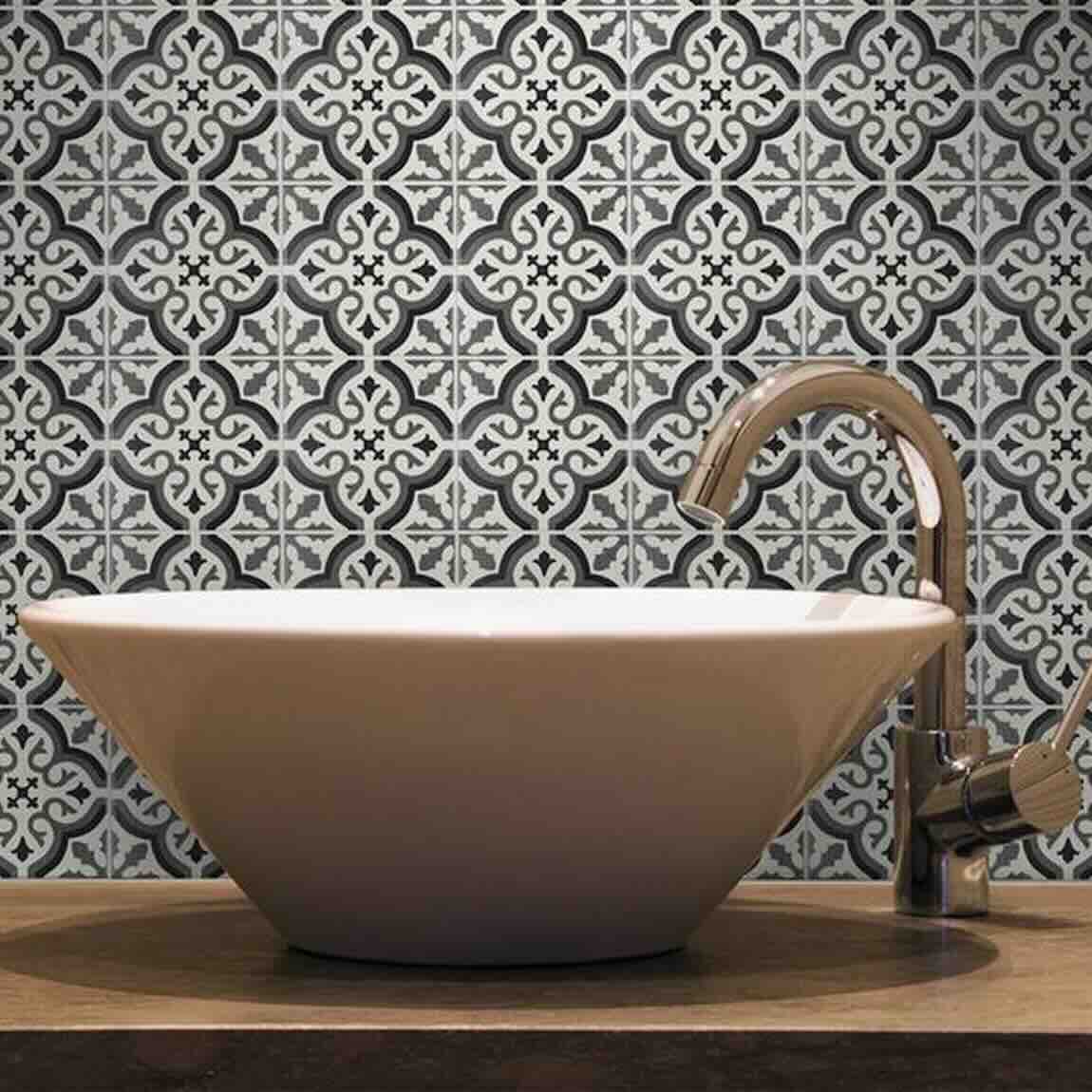 White freestanding sink with a decorative tiled wall black and white in a bathroom setting
