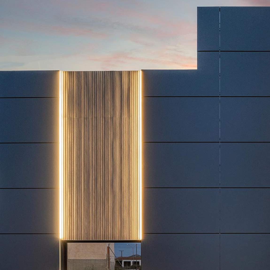 The Eco Slatted Decorative Wall Panel Flow Oak 8x96 featured on a building facade