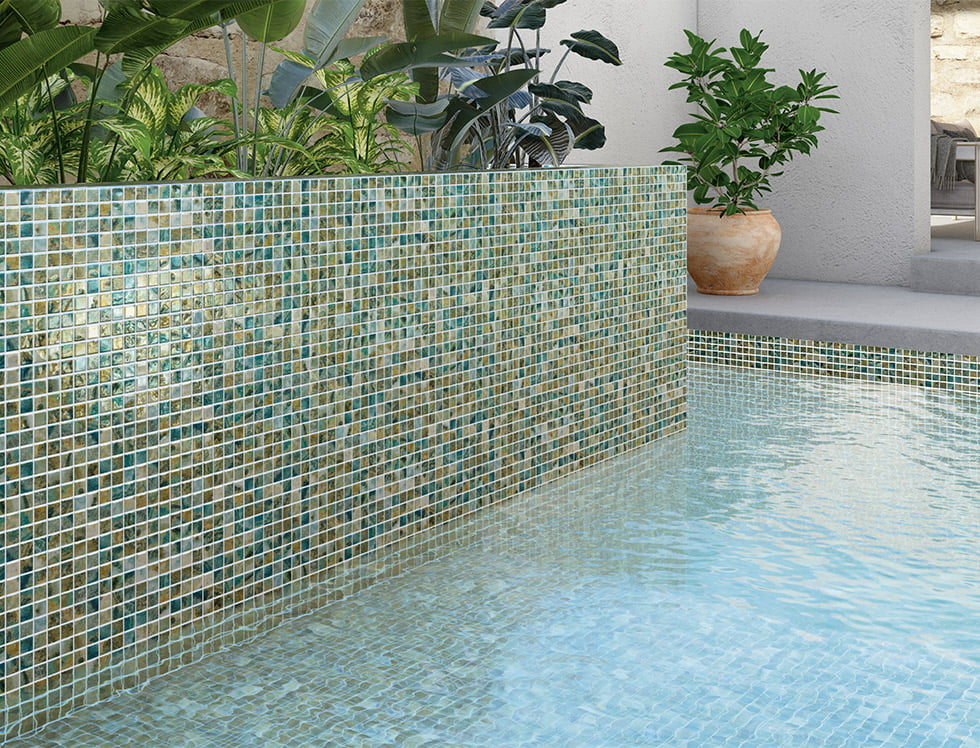 Recycled glass mosaic tile from the Kriti series installed in a swimming pool, offering an eco-friendly design with a shimmering, colorful finish that enhances the pool’s natural sparkle