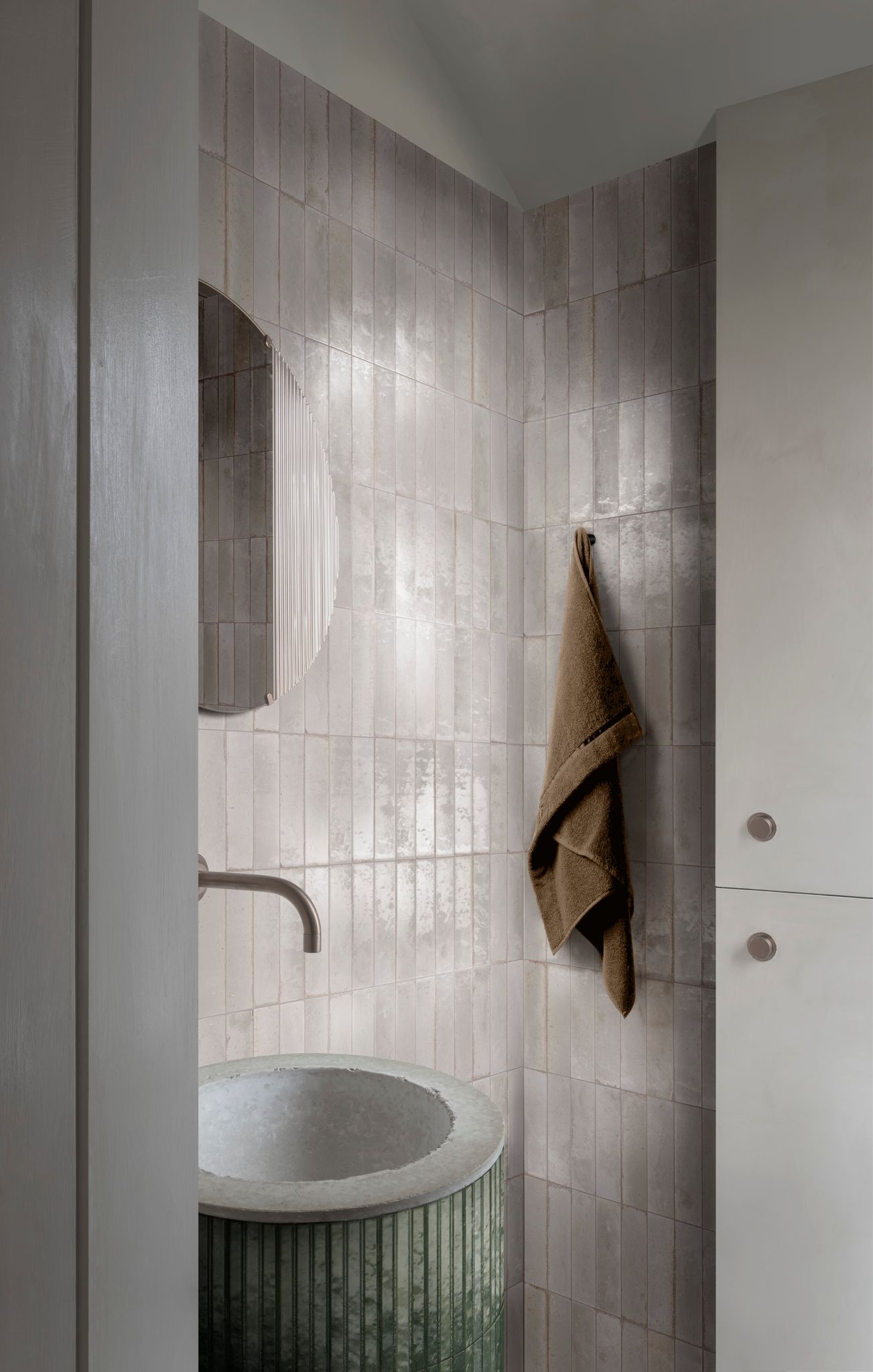Distressed white 2.5x9.5 subway tile in Bianco shade, installed on a bathroom wall for a soft vintage look with timeless charm