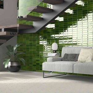 Petite Ville Subway Porcelain Tile Olive 2x6 featured on a living room accent wall