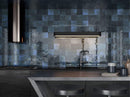 kitchen backsplash featuring dark blue tiles and black countertop