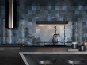 kitchen backsplash featuring dark blue tiles and black countertop