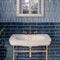 Chic Bathroom featuring blue tiles. white sink, and gold hardware