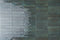 City Distressed Subway Tile Emerald Glossy 2x10 installed on a wall