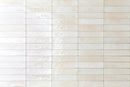 City Distressed Subway Tile Ivory Glossy 2x10 installed on a wall