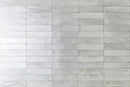 City Distressed Subway Tile Light Grey Glossy 2x10 installed on a wall