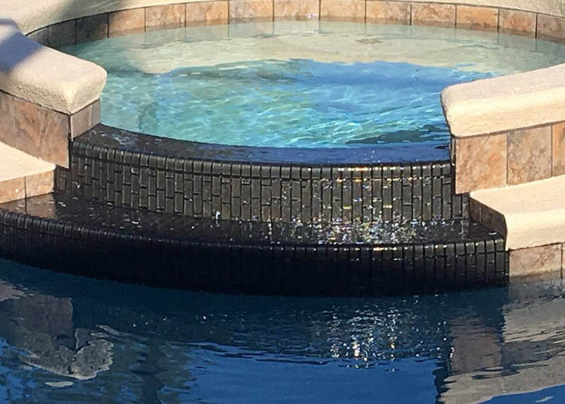 Spa featuring an iridescent glass tile in a charcoal color